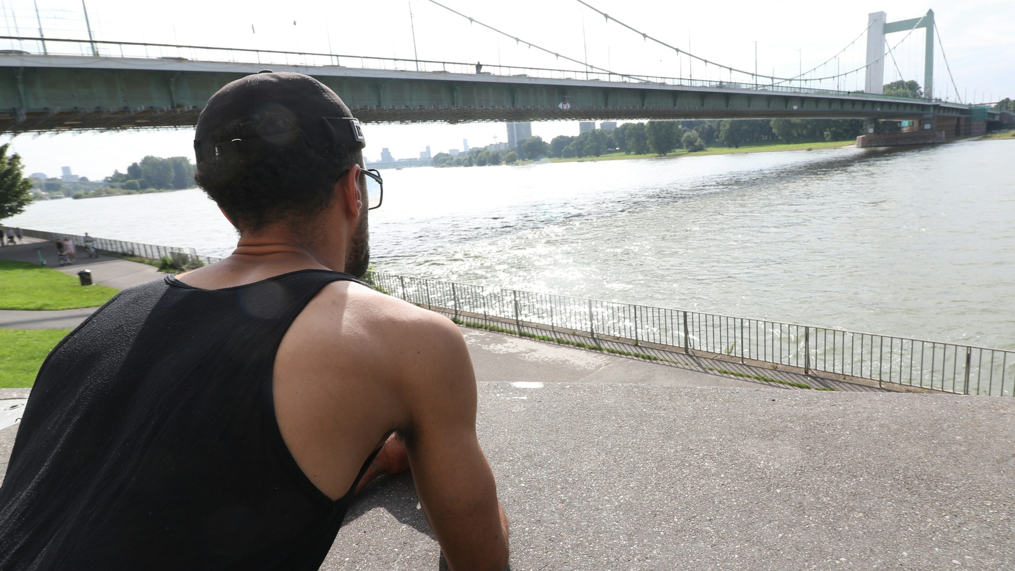 Patrick K. steht am Rheinufer in Mülheim.