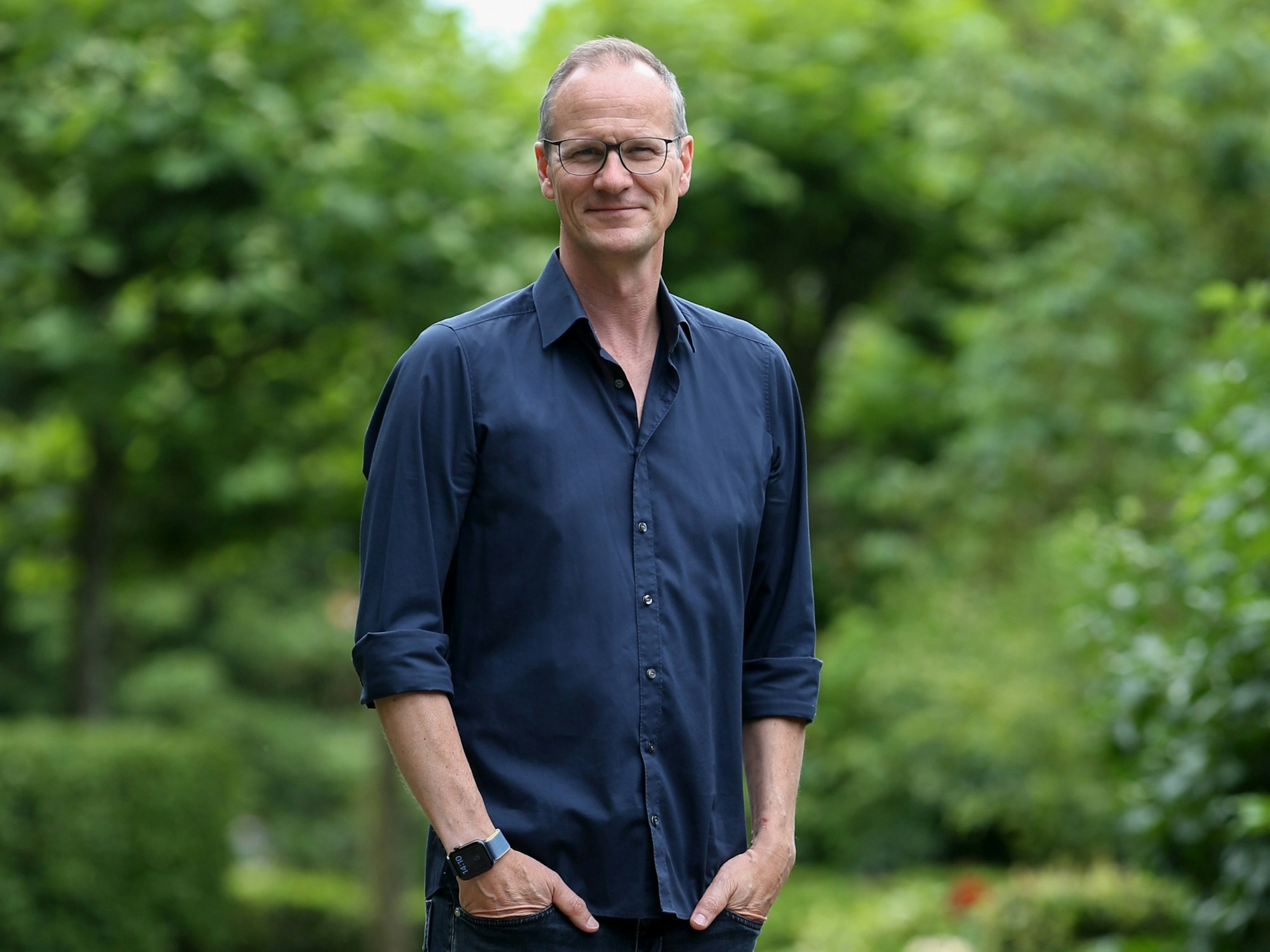 Thomas Bug steht mit den Händen in der Tasche im Rosengarten im Fort X.