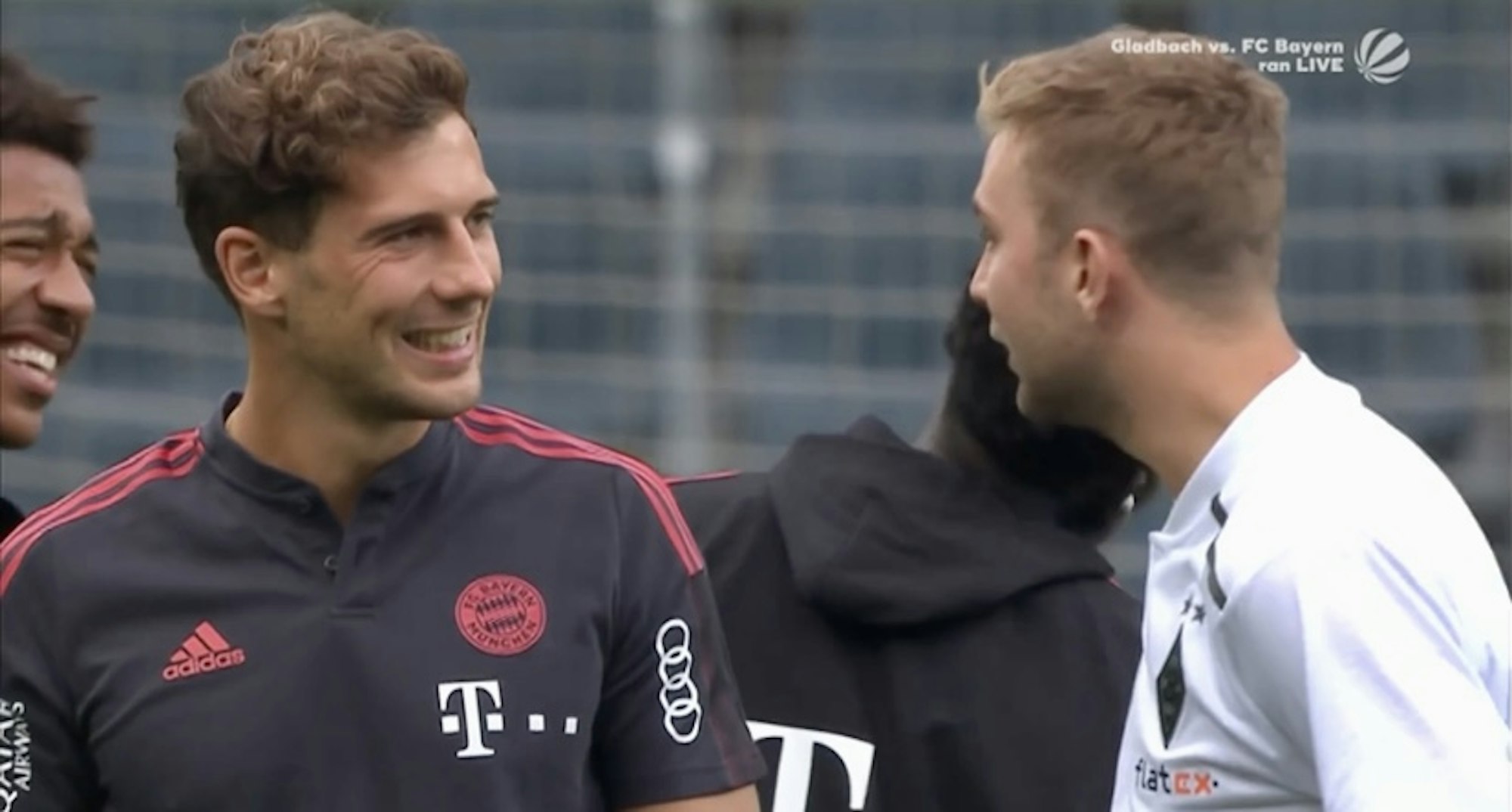 Bayerns Leon Goretzka präsentiert Gladbachs Christoph Kramer seine Zahnschiene vor dem Bundesliga-Auftaktspiel zur Saison 2021/2022.
