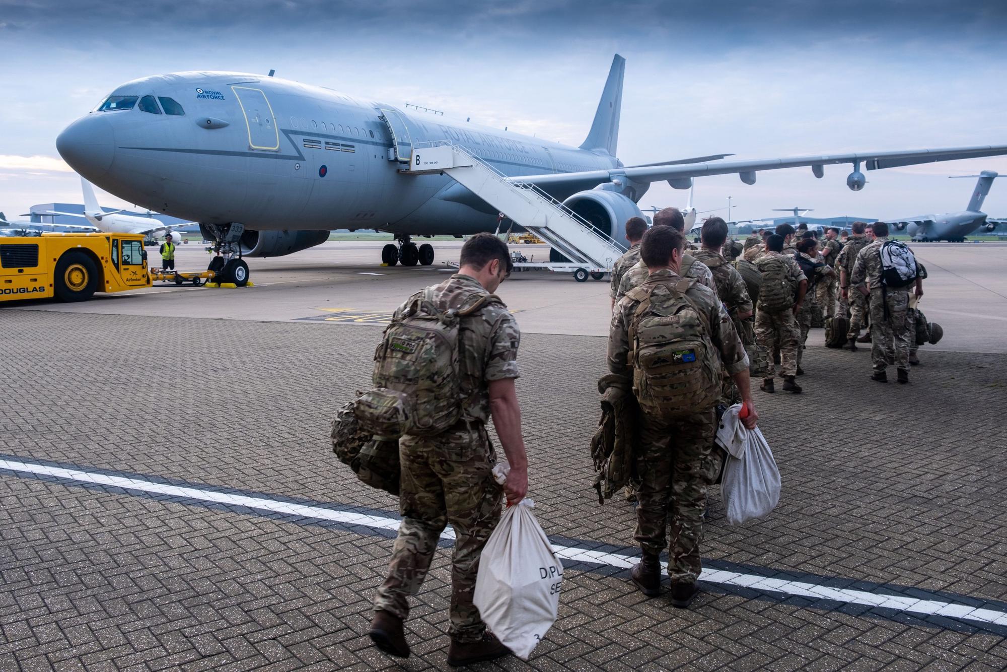 Eine Gruppe von britischen Streitkräften geht an Bord eines Flugzeugs.