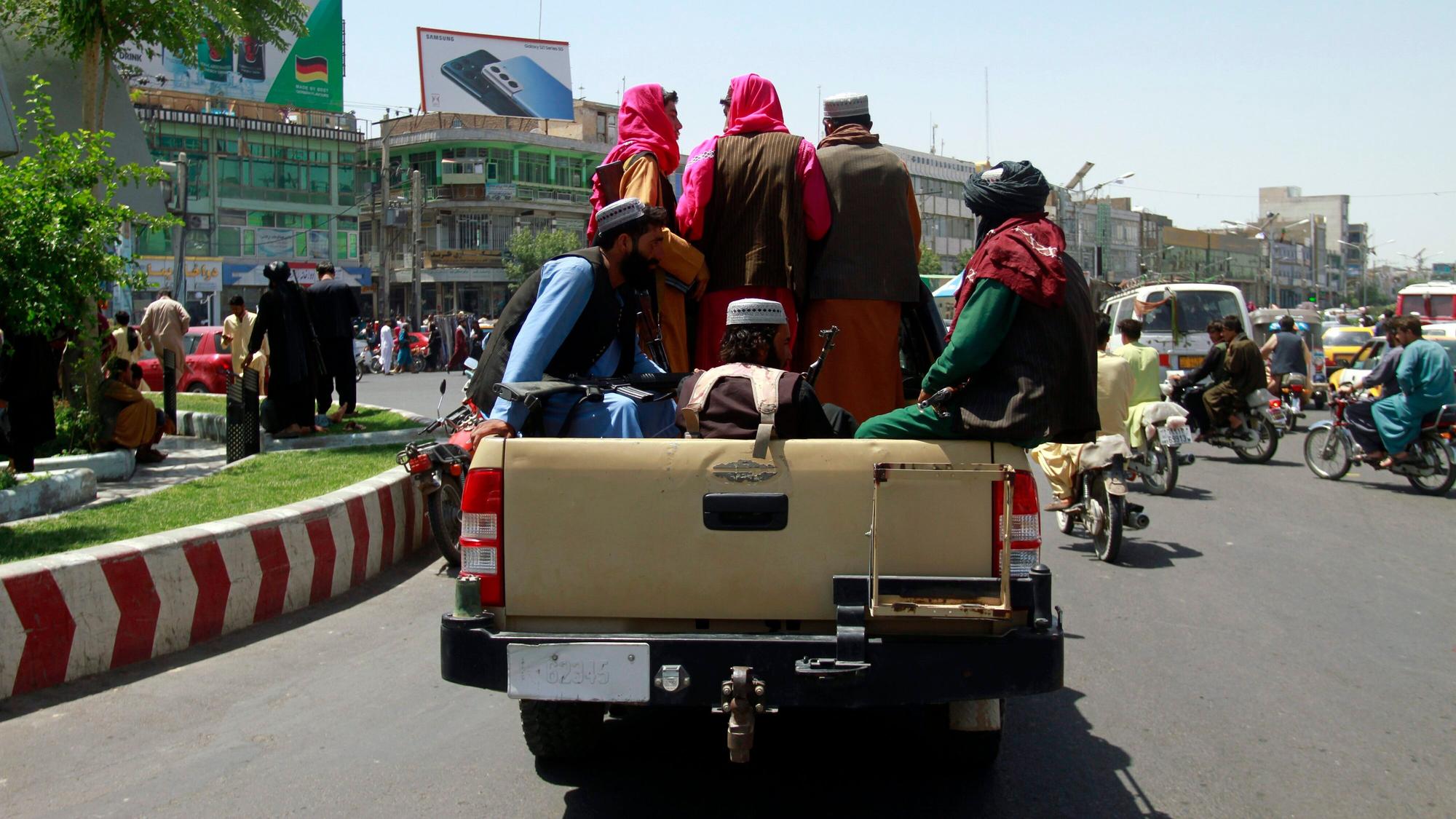 Taliban-Kämpfer sitzen auf der Ladefläche eins Pick-ups. Die militant-islamistischen Taliban setzen ihren Vormarsch in Afghanistan fort und rücken dabei immer näher an die Hauptstadt Kabul heran. Aus der Stadt Herat, im Westen Kabuls, sorgen schreckliche Bilder und Videos weltweit für Aufregung.