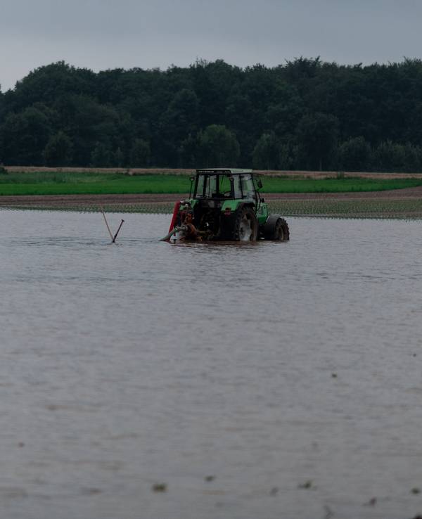 Ein Traktor steht auf einem gefluteten Feld bei Heimerzheim.