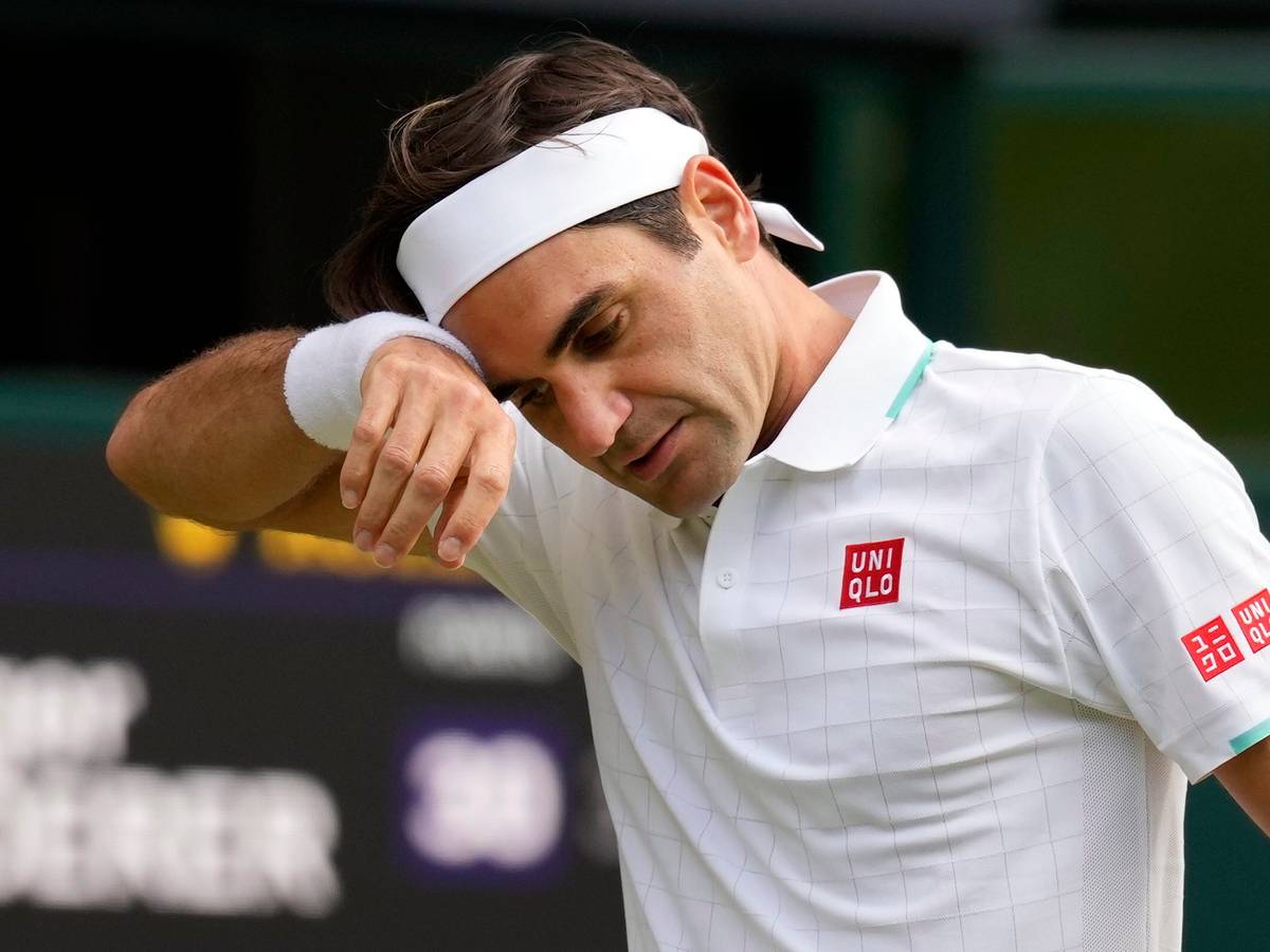 Der Schweizer Roger Federer wischt sich im Wimbledon-Viertelfinale gegen Hubert Hurkacz den Schweiß von der Stirn.
