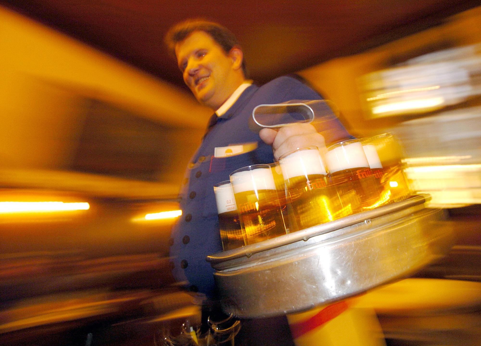 Ein "Köbes", ein Wirt in einem Kölsch-Brauhaus in der Kölner Innenstadt serviert am Donnerstag Kölsch.