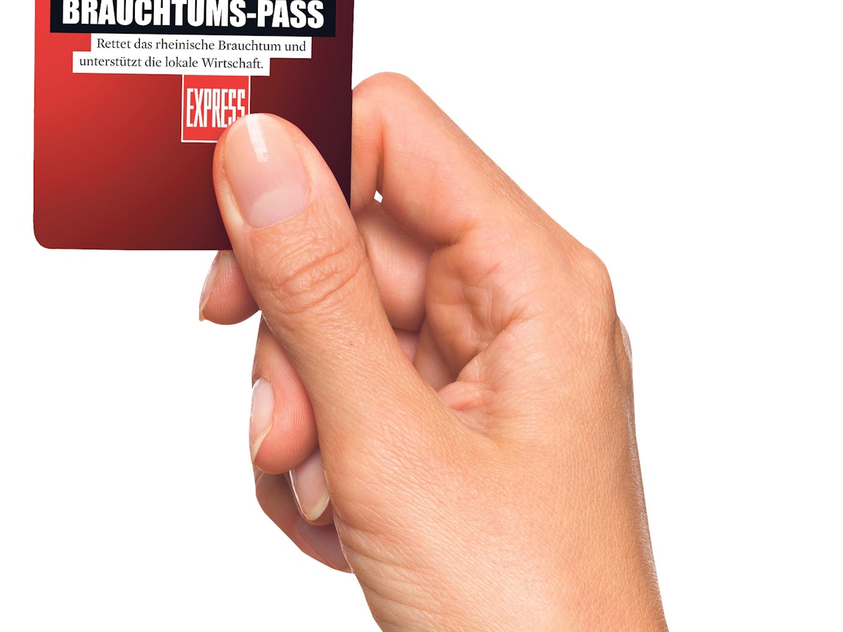 Eine Hand hält den Brauchtums-Pass für Köln.