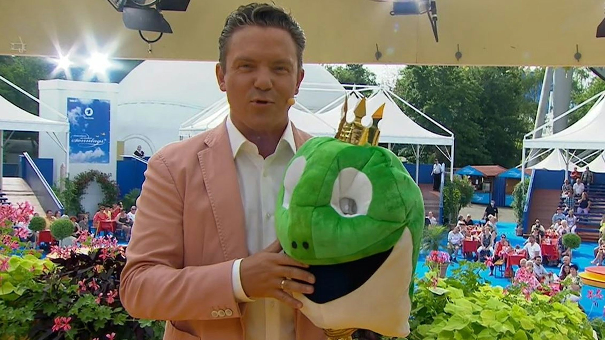 Stefan Mross steht am 15. August bei „‚Immer wieder sonntags‘“ mit einem Froschkopf auf der Bühne