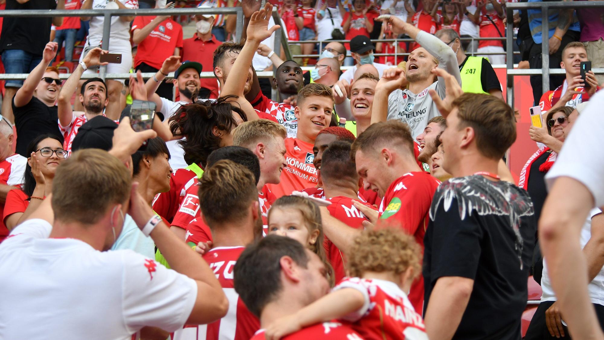 Spieler von Mainz feiern den Sieg gegen Leipzig mit den Fans auf der Tribüne.