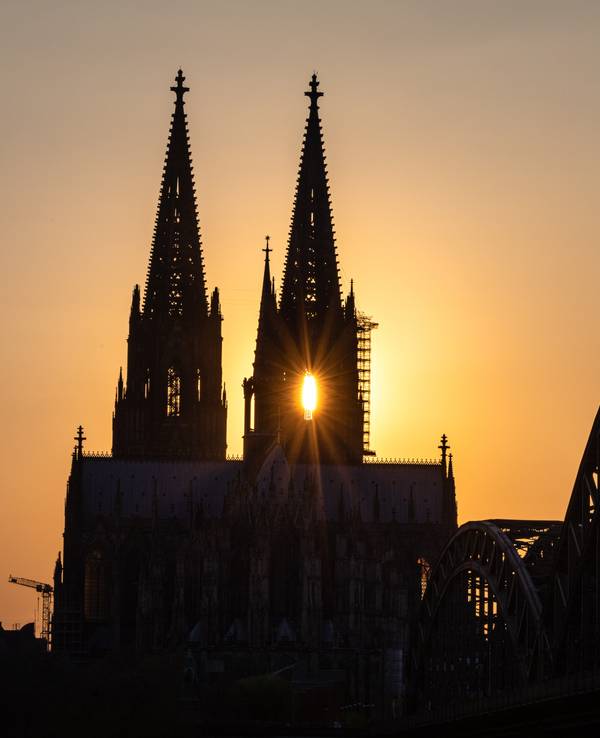 Die Sonne geht hinter dem Kölner Dom unter.