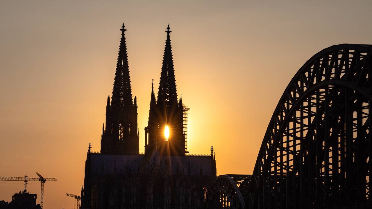 Die Sonne geht hinter dem Kölner Dom unter.