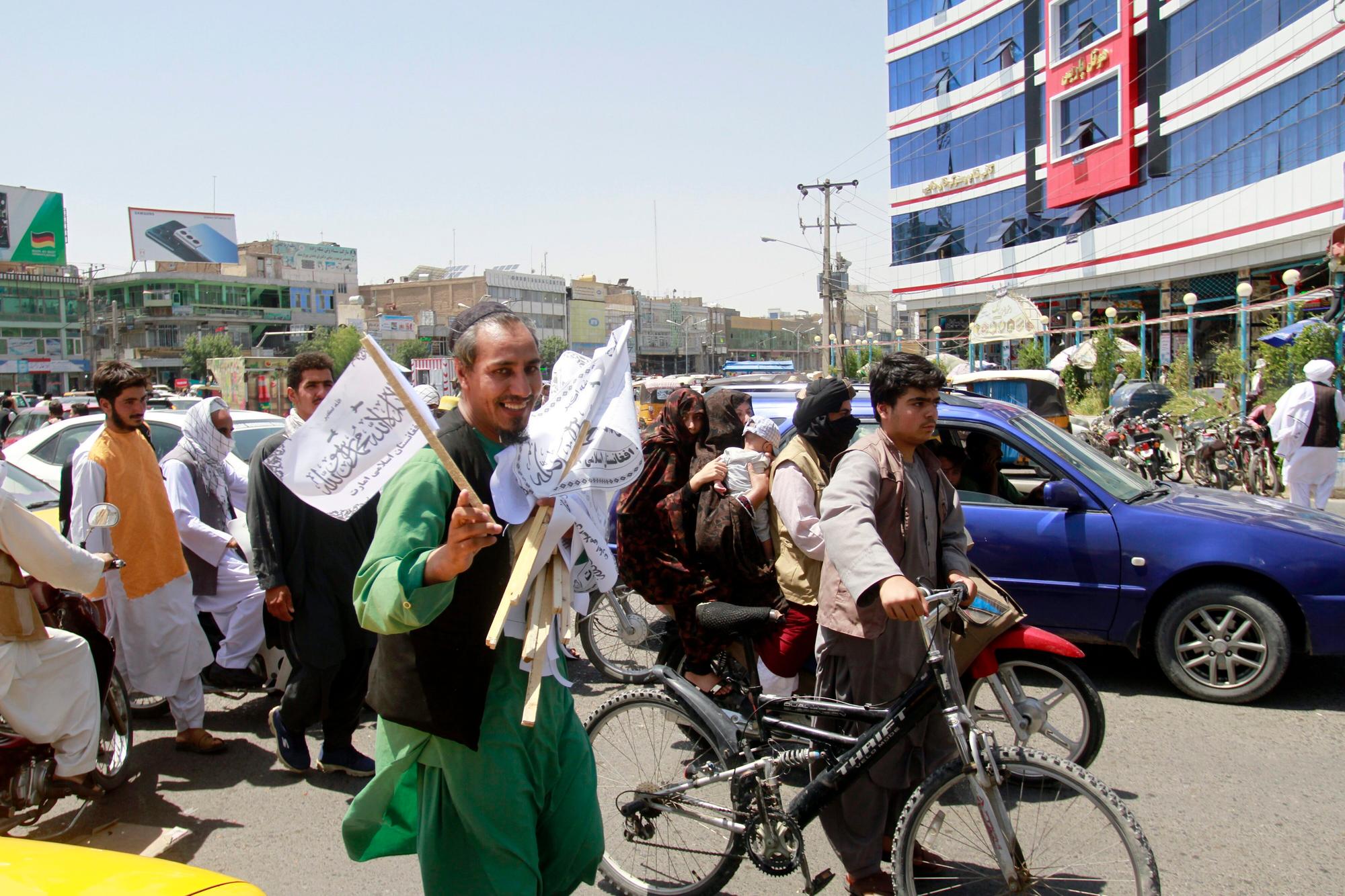 A man sells Taliban flags in Herat province, west of Kabul, Afghanistan, on Saturday, Aug. 14, 2021. (AP Photo/Hamed Sarfarazi)