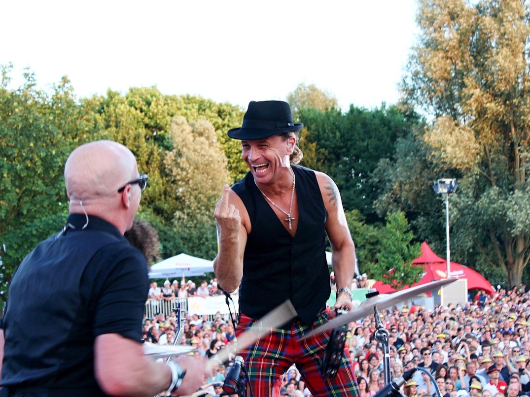 Kölschrocker Peter Brings (r.) zeigt Schlagzeuger Christian Blüm bei einem Konzert den Mittelfinger.