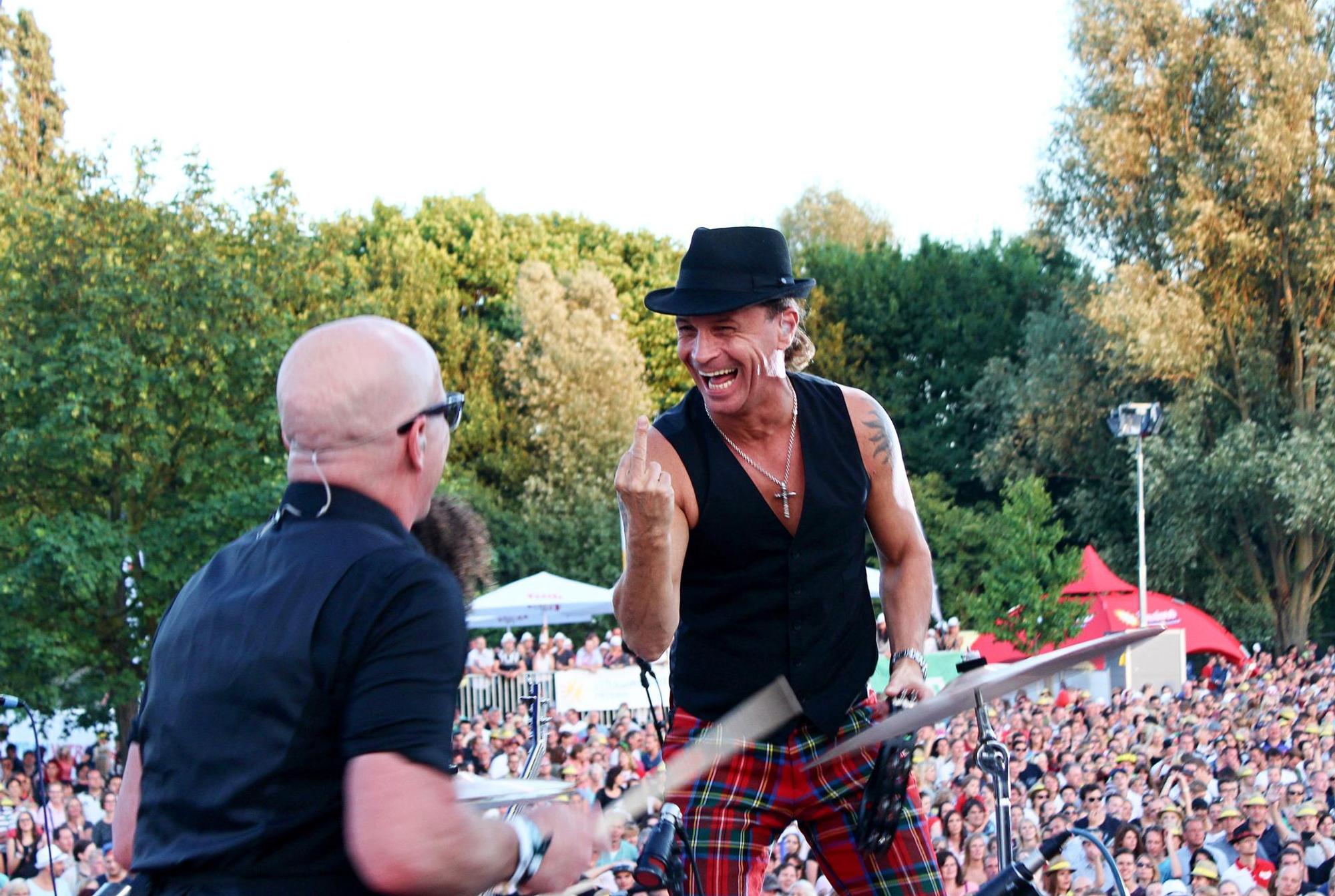 Kölschrocker Peter Brings (r.) zeigt Schlagzeuger Christian Blüm bei einem Konzert den Mittelfinger.