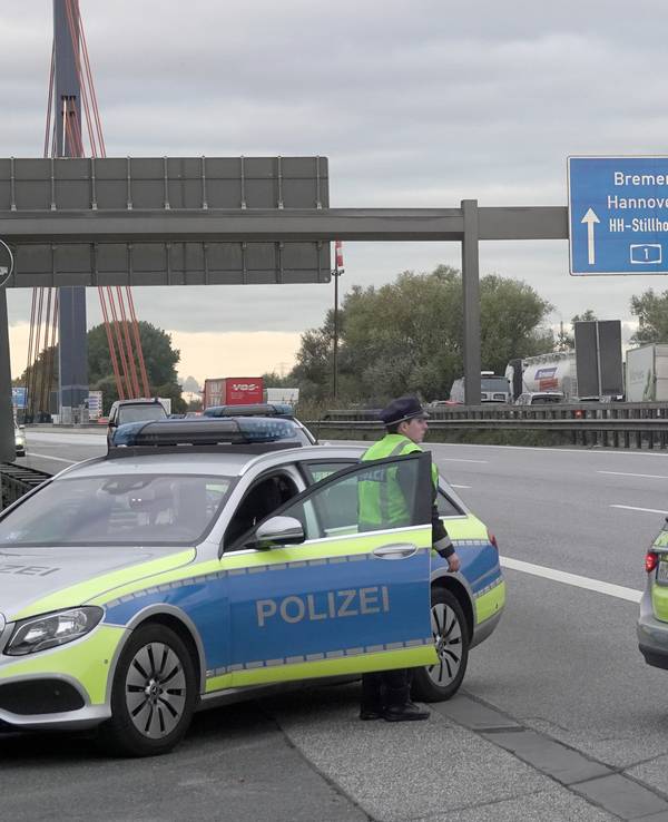 Einsatzfahrzeuge der Polizei stehen auf der gesperrten Autobahn 1.