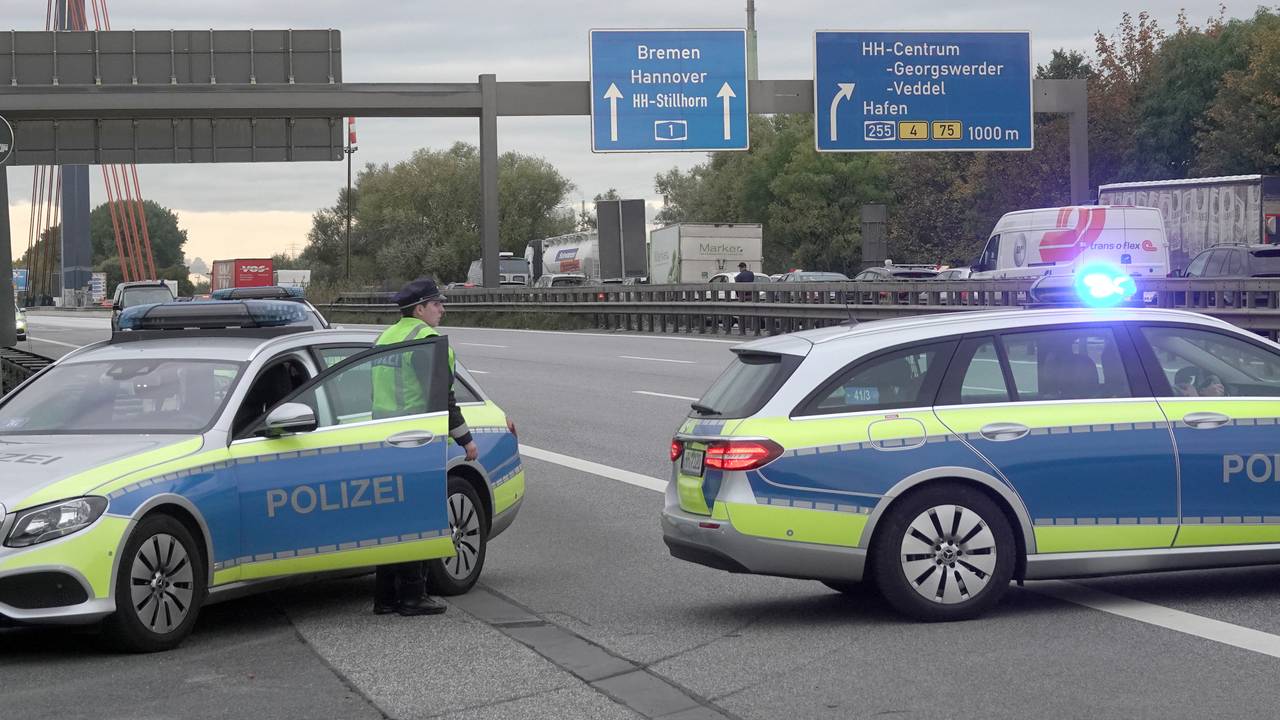 Einsatzfahrzeuge der Polizei stehen auf der gesperrten Autobahn 1.