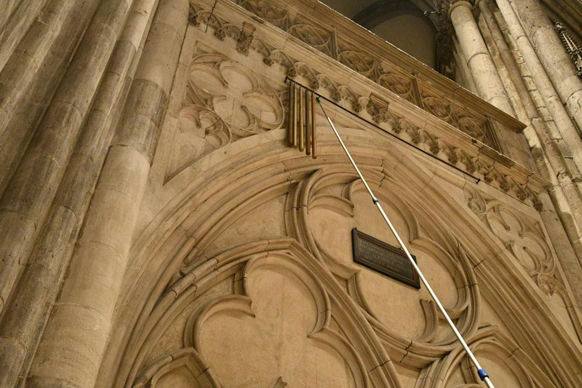 Goldene Holzstöcke hängen im Kölner Dom.