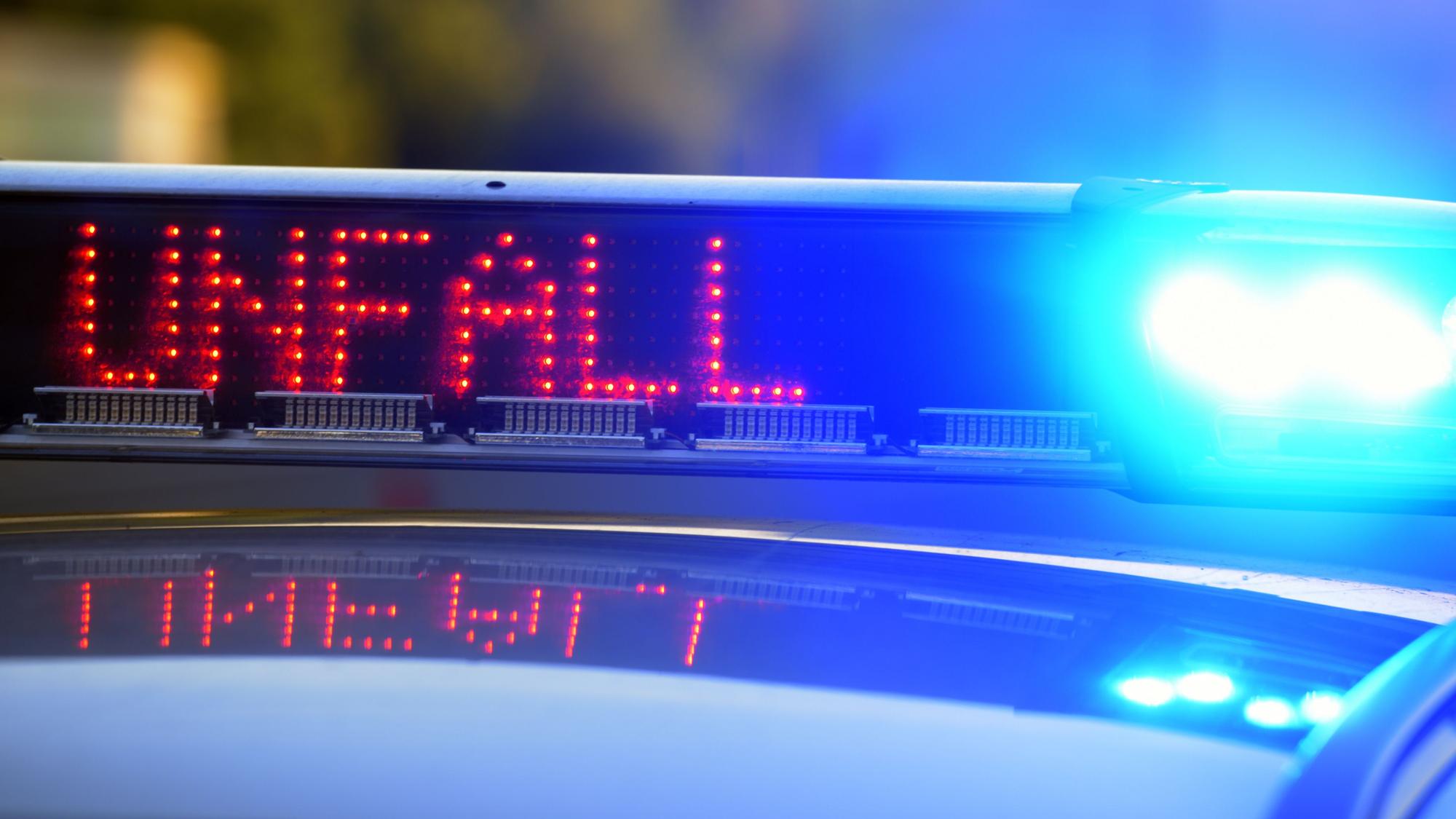 Auf einem Polizeifahrzeug warnt auf der Autobahn A8 eine Leuchtschrift vor einer Unfallstelle.