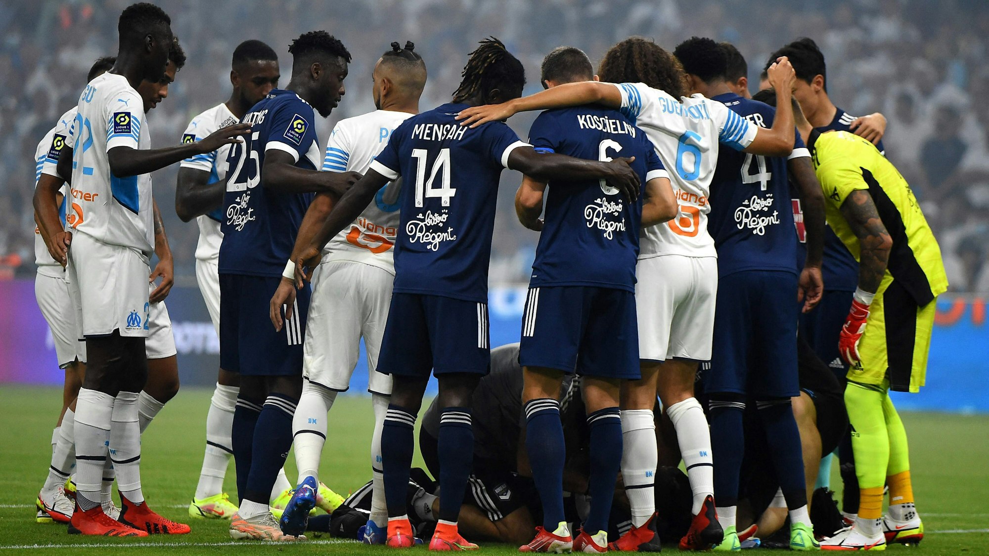 Spieler von Bordeaux und Marseille stehen um den zusammengebrochenen Samuel Kalu
