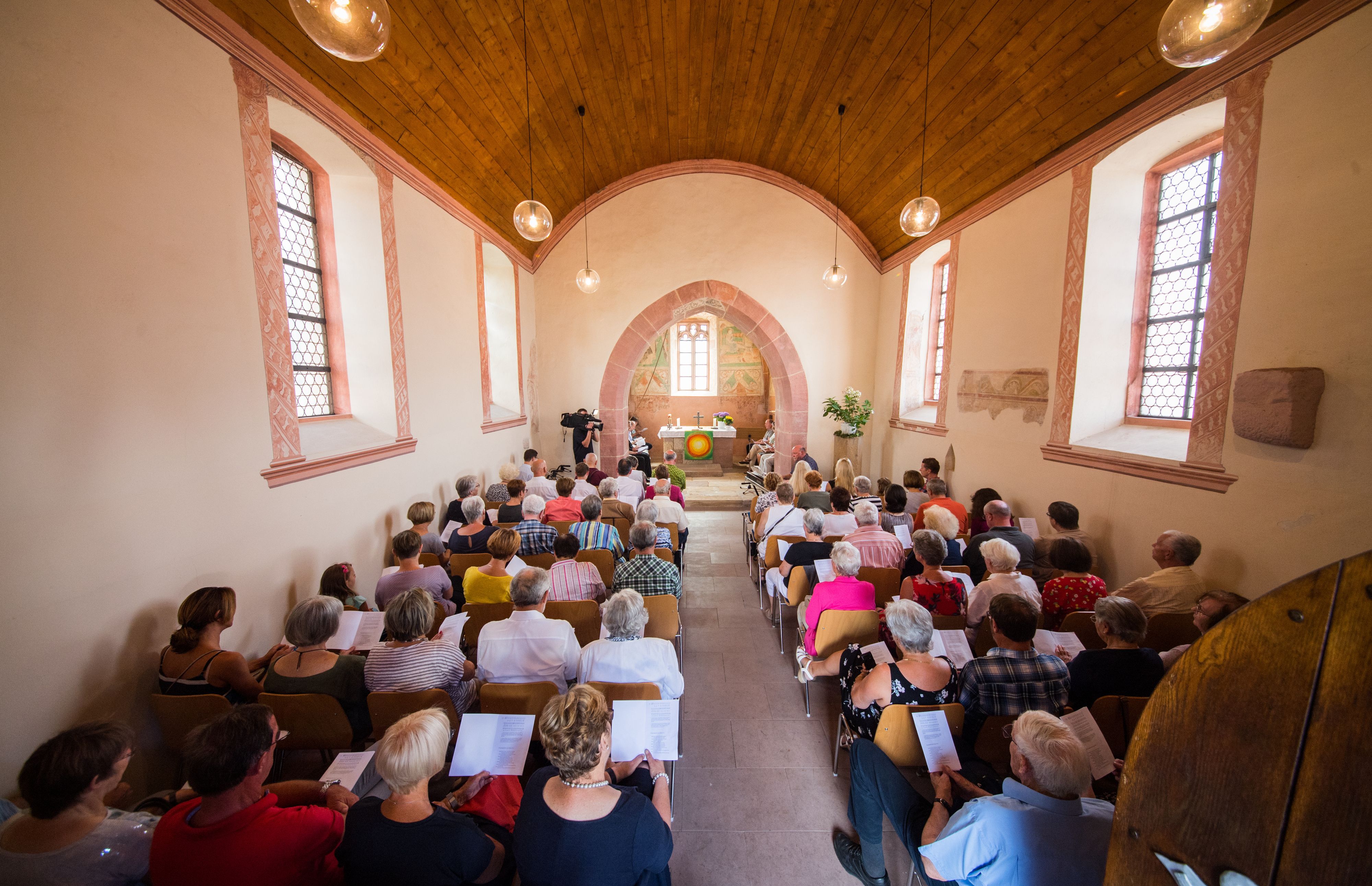 Die Kirchengemeinde sitzt beim Gottesdienst in der Kapelle.
