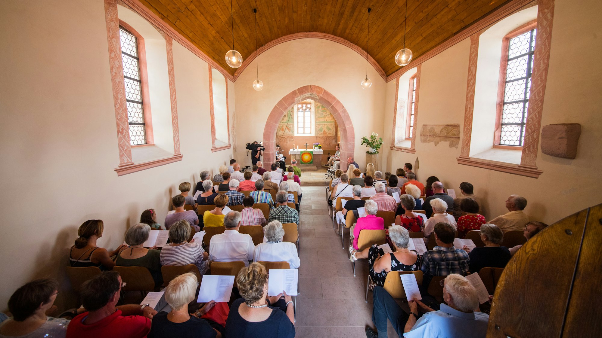 Die Kirchengemeinde sitzt beim Gottesdienst in der Kapelle.