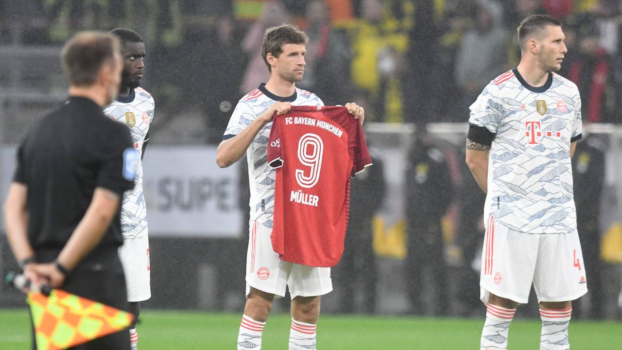 Thomas Müller hält ein Trikot in die Luft