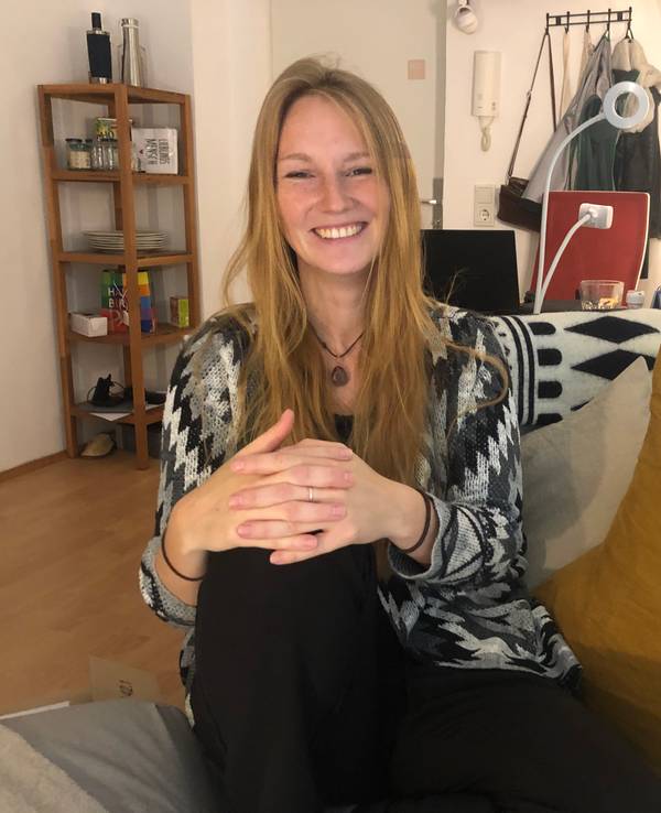 Alexandra Schmidt sitzt auf dem Sofa in ihrer Wohnung in Köln-Deutz.