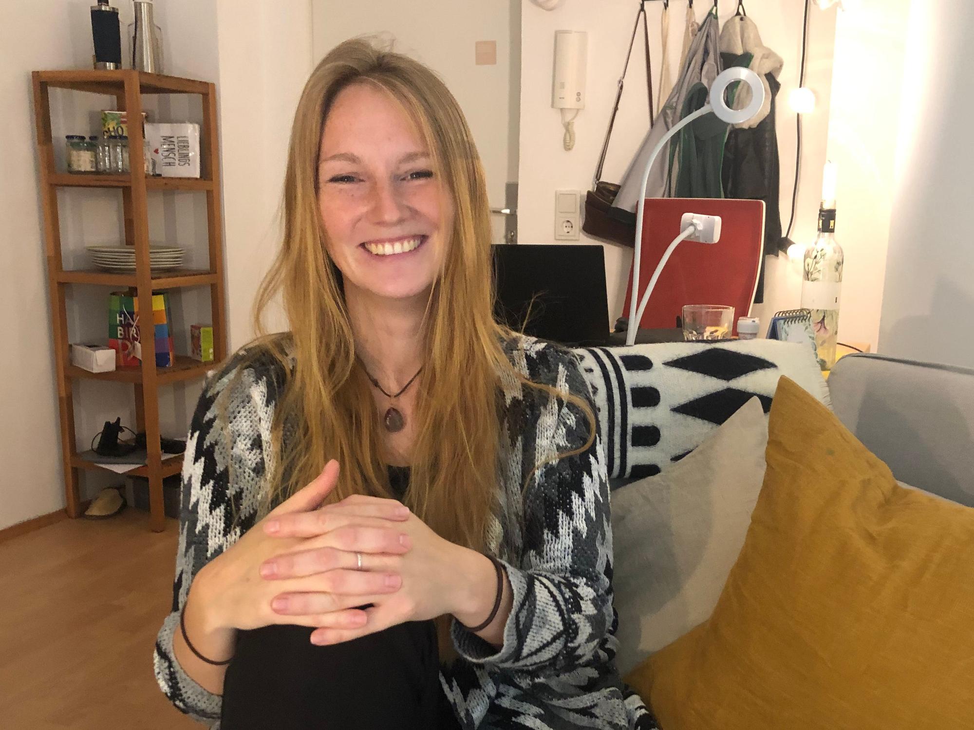 Alexandra Schmidt sitzt auf dem Sofa in ihrer Wohnung in Köln-Deutz.