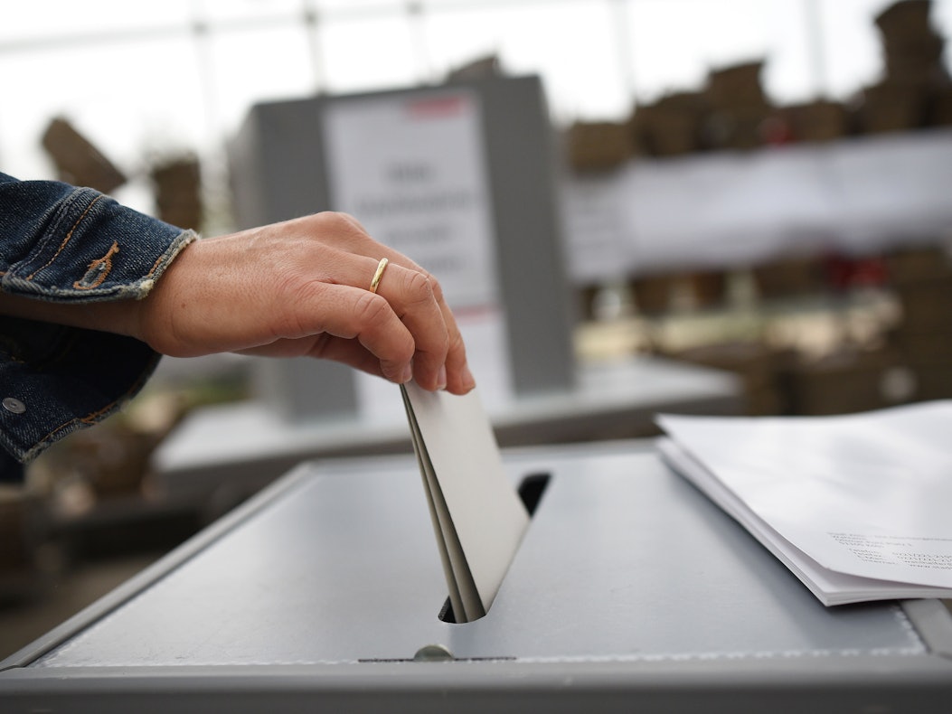 Die diesjährige Bundestagswahl soll in den Flutgebieten in Zelten, Bussen oder Containern stattfinden können. Eine Frau wirft ihren Wahlzettel in eine Urne, die sich im Gewächshaus einer Gärtnerei befindet.