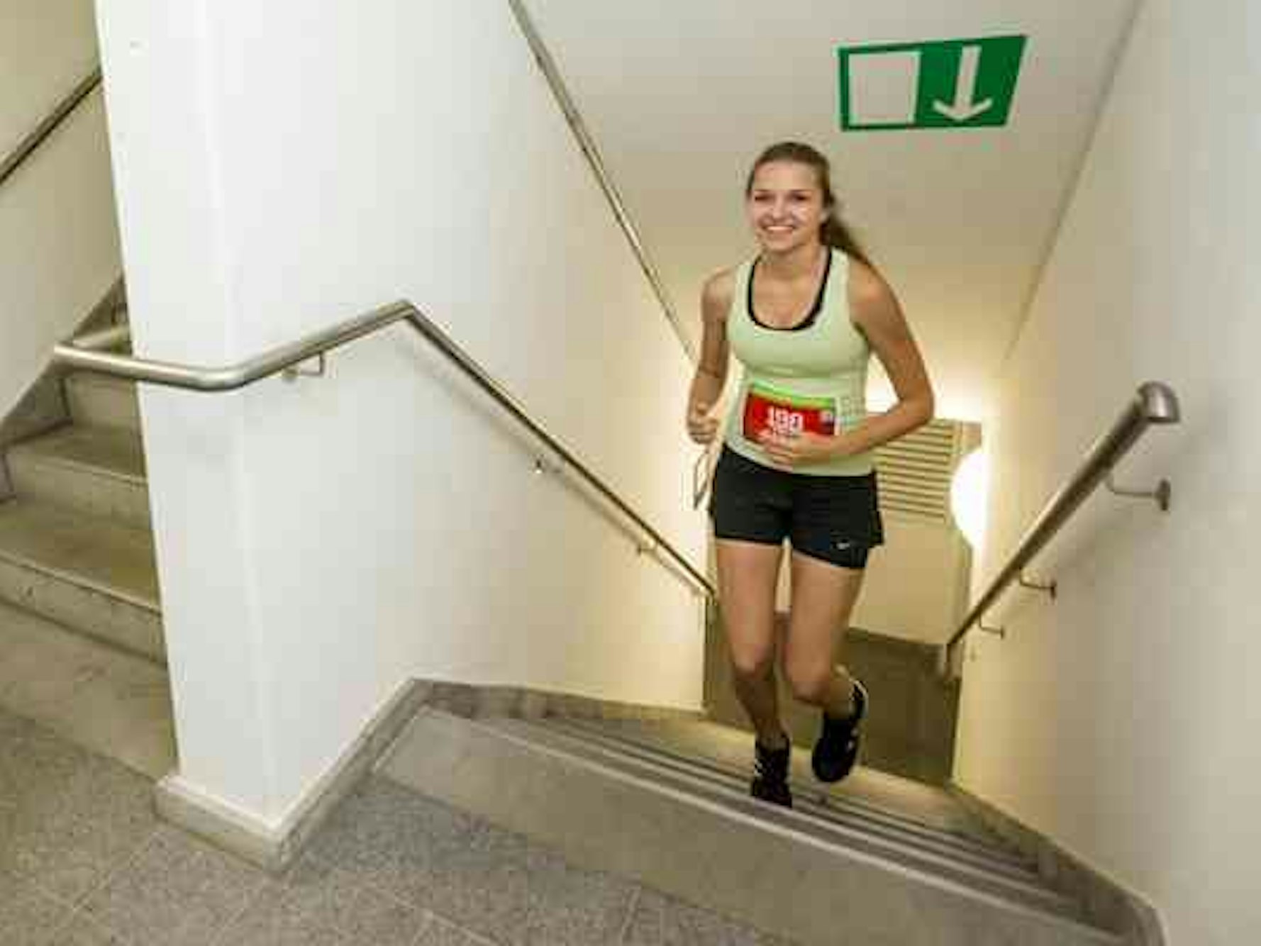 Eine Sportlerin läuft bei der Treppenlaufmeisterschaft ein Treppenhaus hoch.