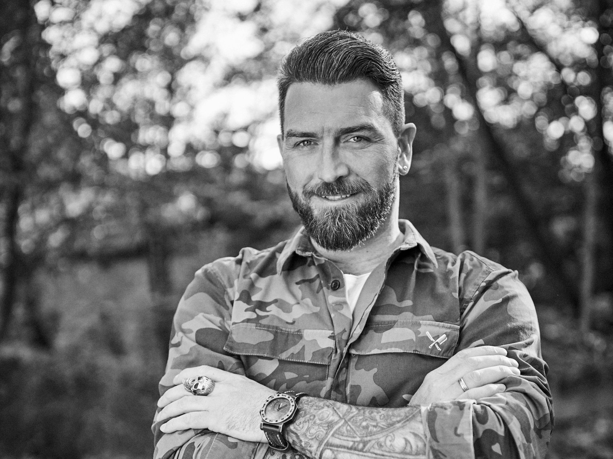 Ingo Kantorek steht mit verschränkten Armen, lächelnd da.