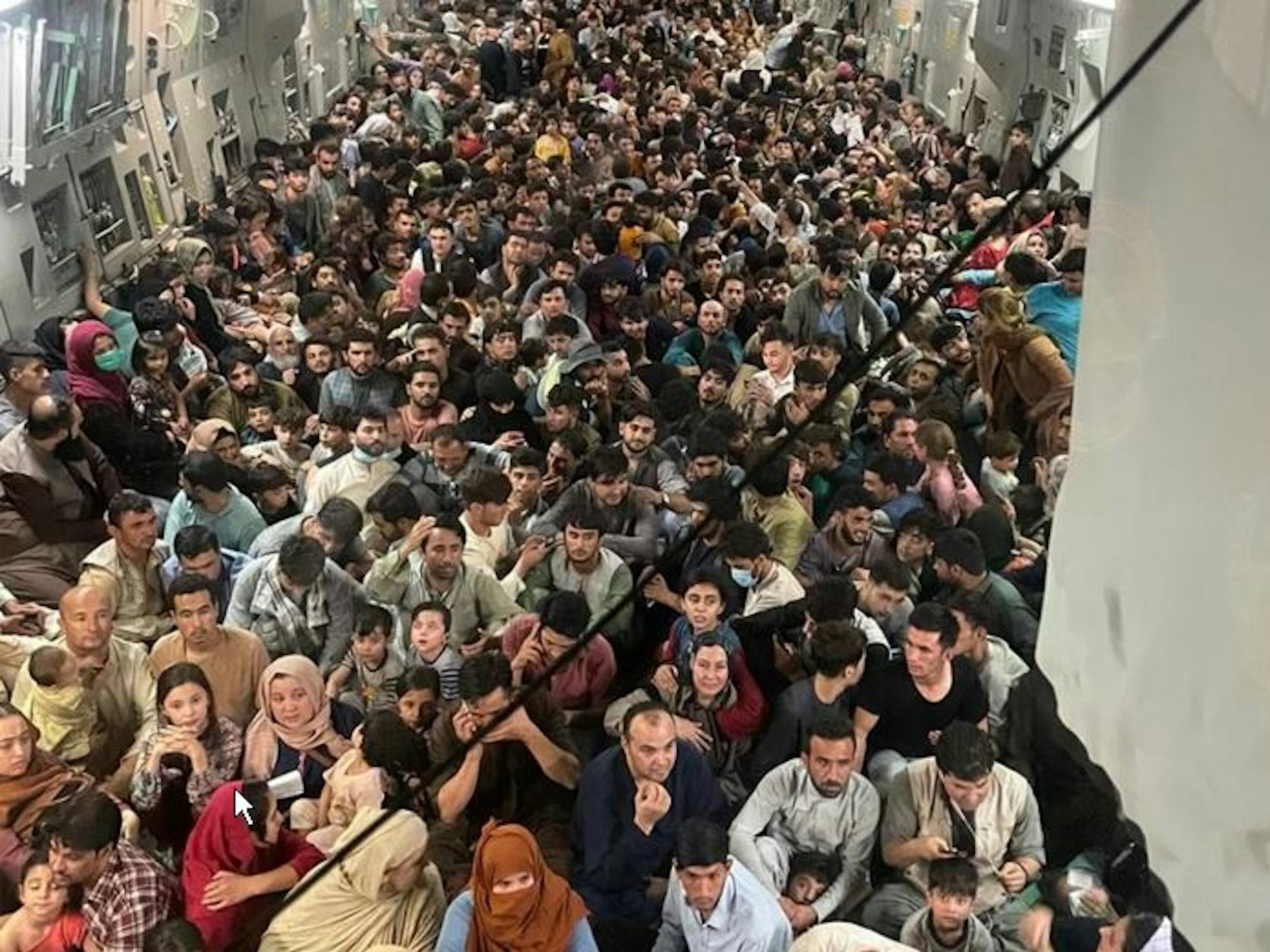 15.08.2021, Afghanistan, Kabul: Zahlreiche Afghanen sind an Bord einer Transportmaschine vom Typ C-17 der US-Airforce. Defense One veröffentlichte  dieses Foto des vollgepackten Innenraums der Transportmaschine vom Typ C-17, in dem die Afghanen auf dem Boden sitzen - der vor lauter Menschen nicht mehr zu sehen ist.