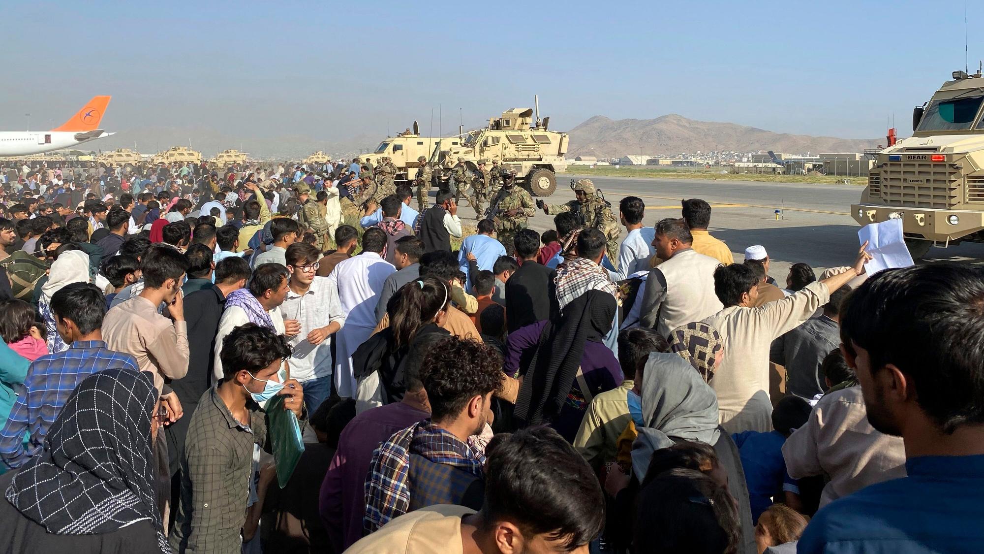 Hunderte Zivilisten stehen auf dem Flughafen von Kabul vor einer Militär-Absperrung.