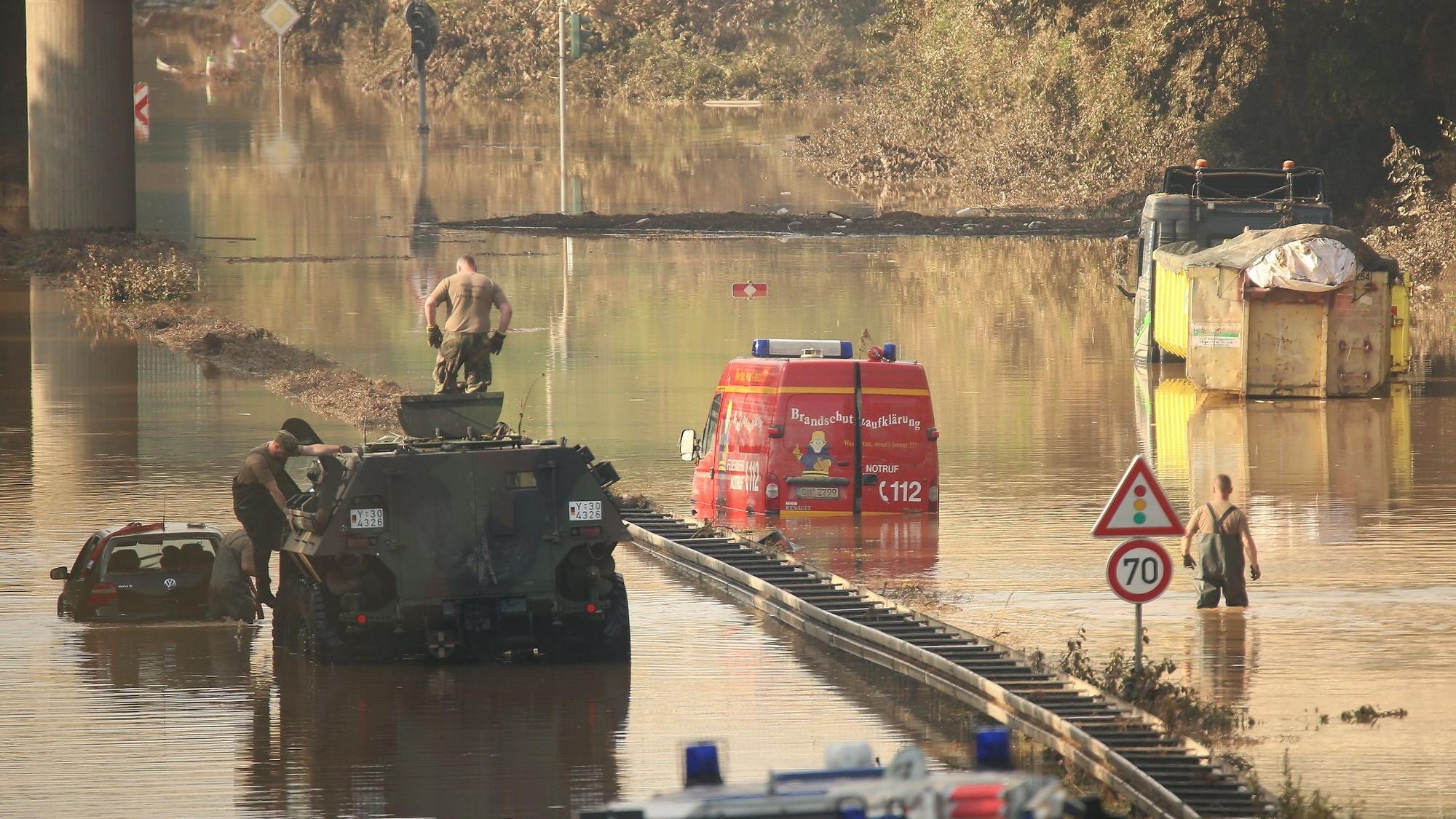 Ein Panzer der Bundeswehr zieht Fahrzeuge aus der Flut.