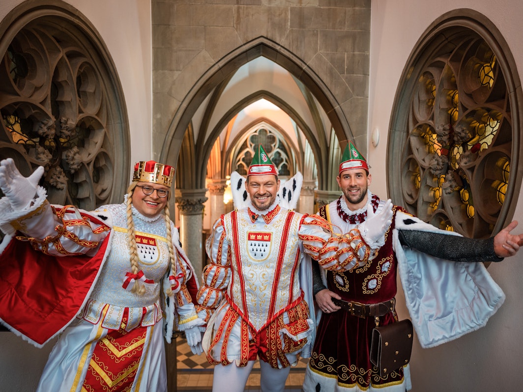 Jungfrau Gerdemie (Björn Braun, l-r), Prinz Sven I. (Sven Oleff) und Bauer Gereon (Gereon Glasemacher), das Kölner Dreigestirn, stehen auf einer Treppe im The Qvest Hotel.