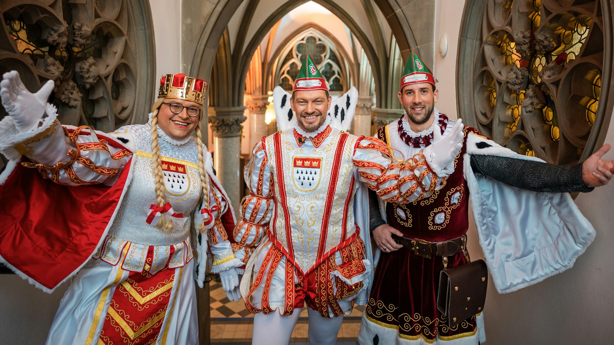 Jungfrau Gerdemie (Björn Braun, l-r), Prinz Sven I. (Sven Oleff) und Bauer Gereon (Gereon Glasemacher), das Kölner Dreigestirn, stehen auf einer Treppe im The Qvest Hotel.