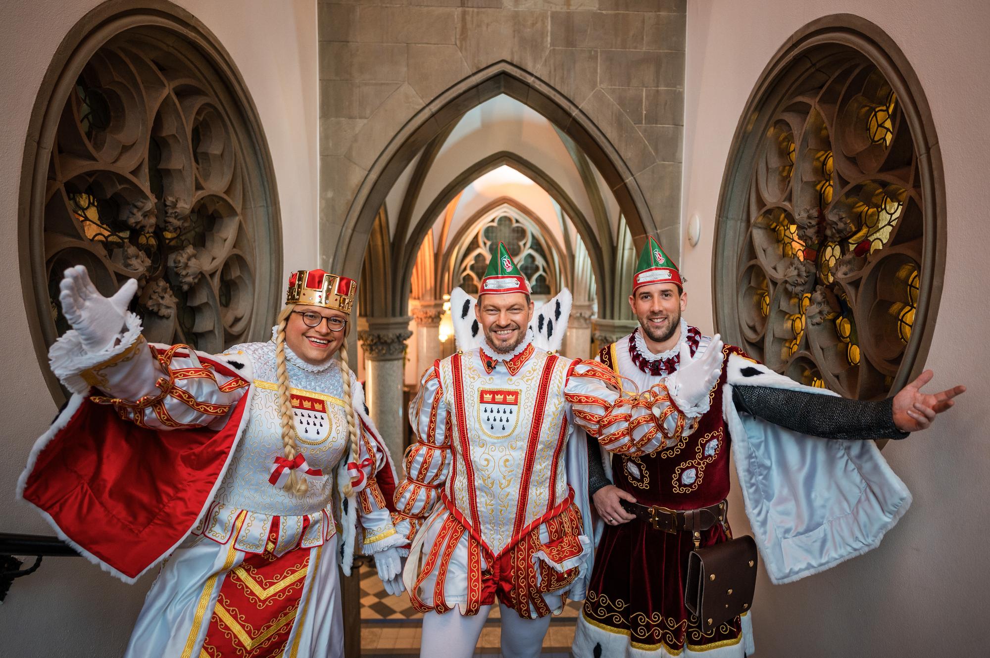 Jungfrau Gerdemie (Björn Braun, l-r), Prinz Sven I. (Sven Oleff) und Bauer Gereon (Gereon Glasemacher), das Kölner Dreigestirn, stehen auf einer Treppe im The Qvest Hotel.