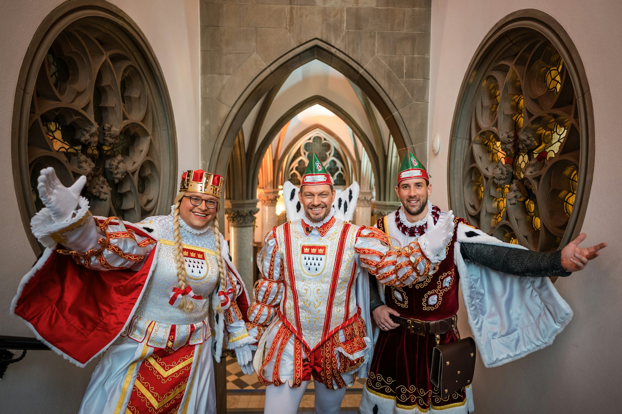 Jungfrau Gerdemie (Björn Braun, l-r), Prinz Sven I. (Sven Oleff) und Bauer Gereon (Gereon Glasemacher), das Kölner Dreigestirn, stehen auf einer Treppe im The Qvest Hotel.