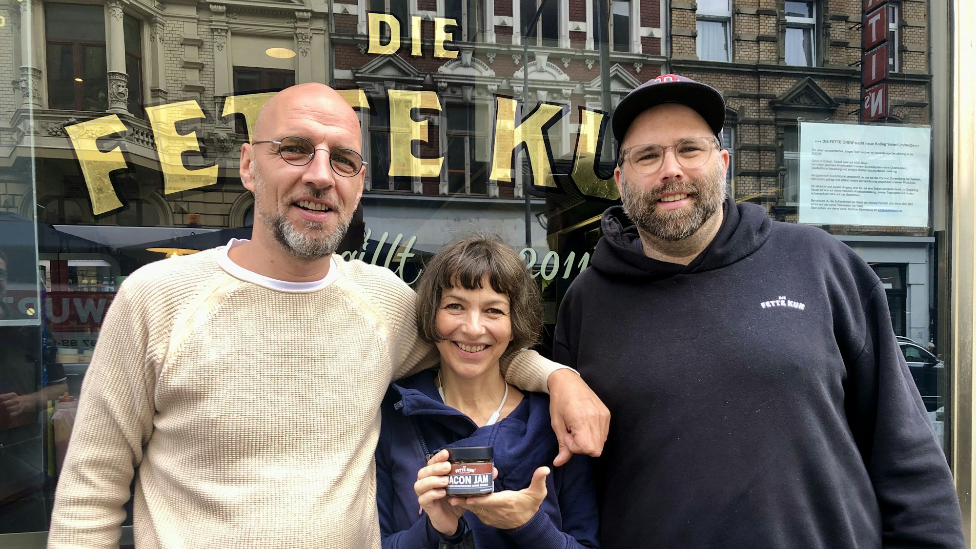Walter Schnerring, Andrea Bratu und Martin Block stehen vor ihrem Burgerladen „Die fette Kuh“.