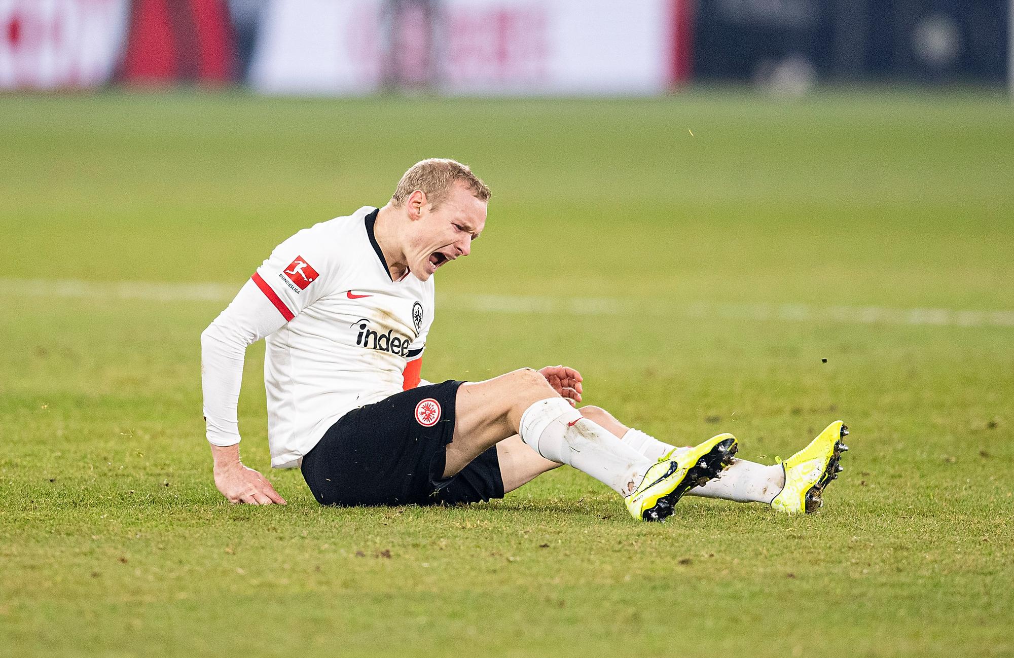 Sebastian Rode sitzt auf dem Rasen und schreit vor Schmerzen.