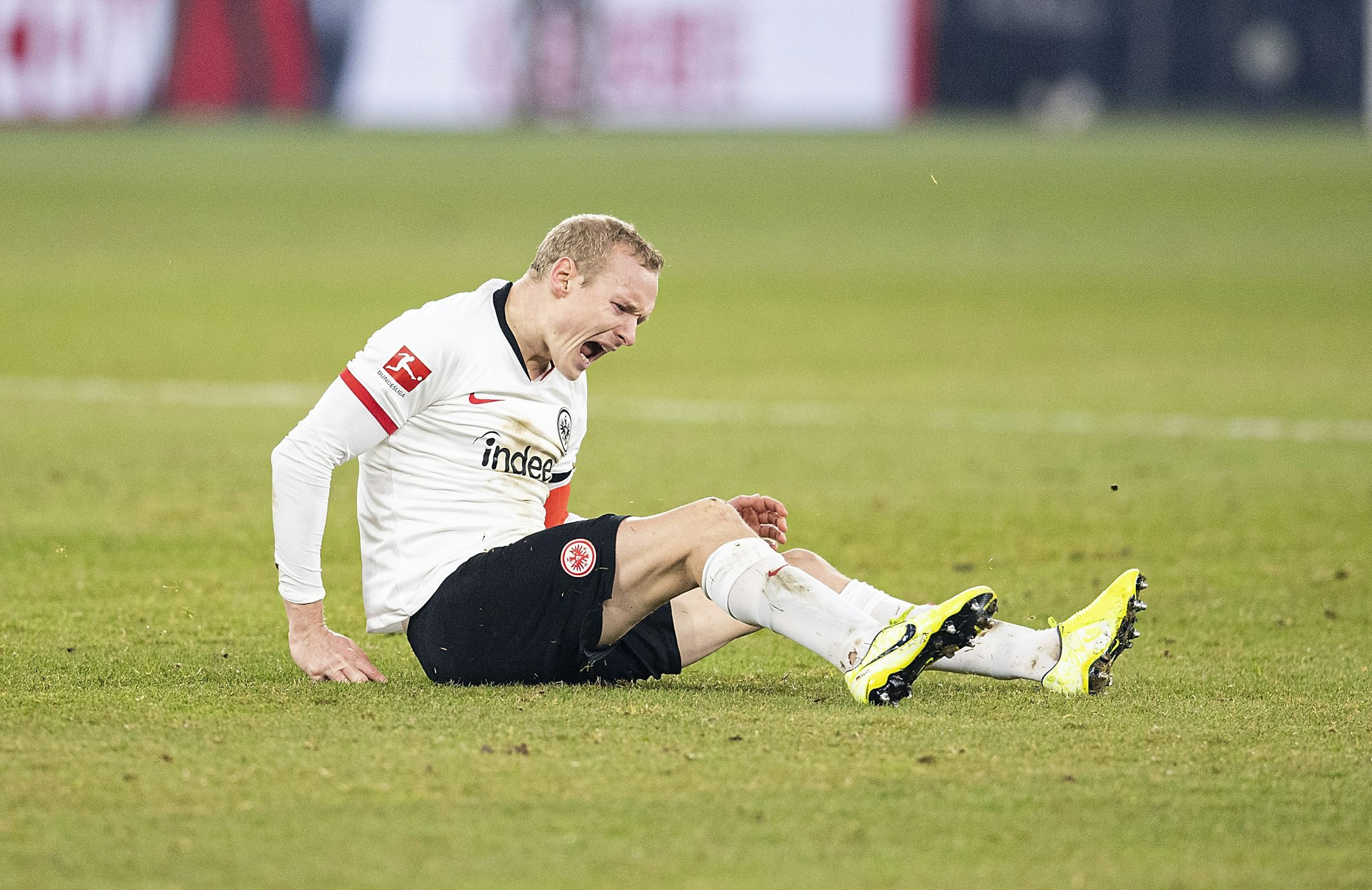 Sebastian Rode sitzt auf dem Rasen und schreit vor Schmerzen.