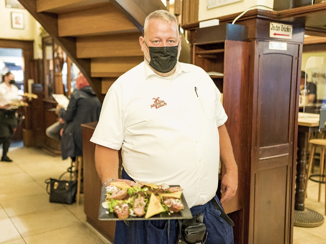 Olaf Goebbels bringt eine Platte mit Kölschen Tappas.