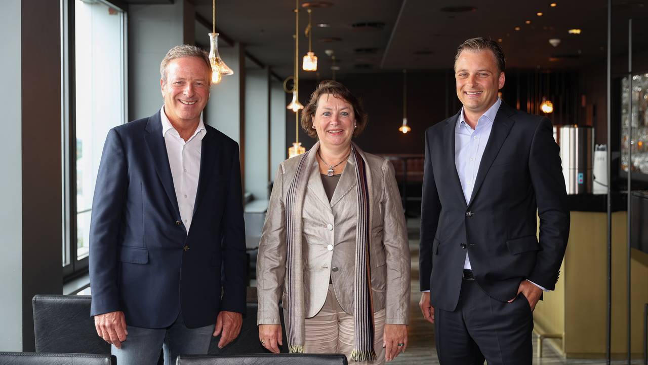 Michael Garvens, Anne Henk-Hollstein und Dr. Konrad Adenauer blicken im Pullman-Hotel in die Kamera.
