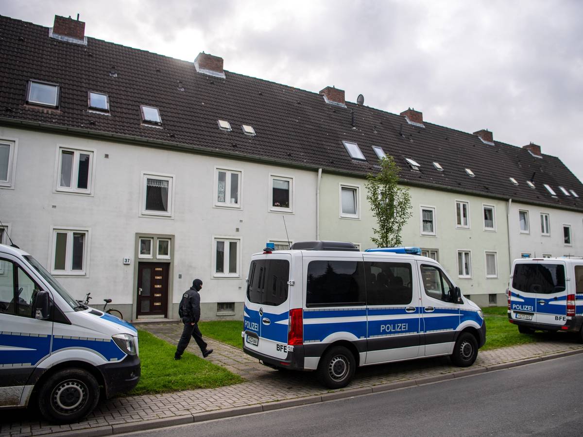 Polizei-Autos vor Wohnhäusern bei einer Razzia. Foto von der dpa, honorarfrei