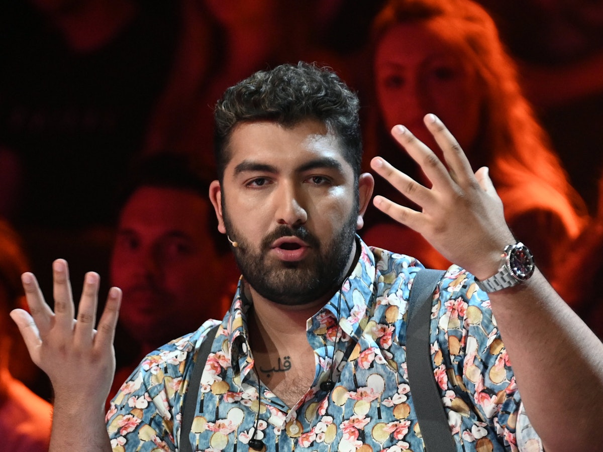 Faisal Kawusi sitzt bei der ProSieben-Show „The Masked Singer“ im Studio.