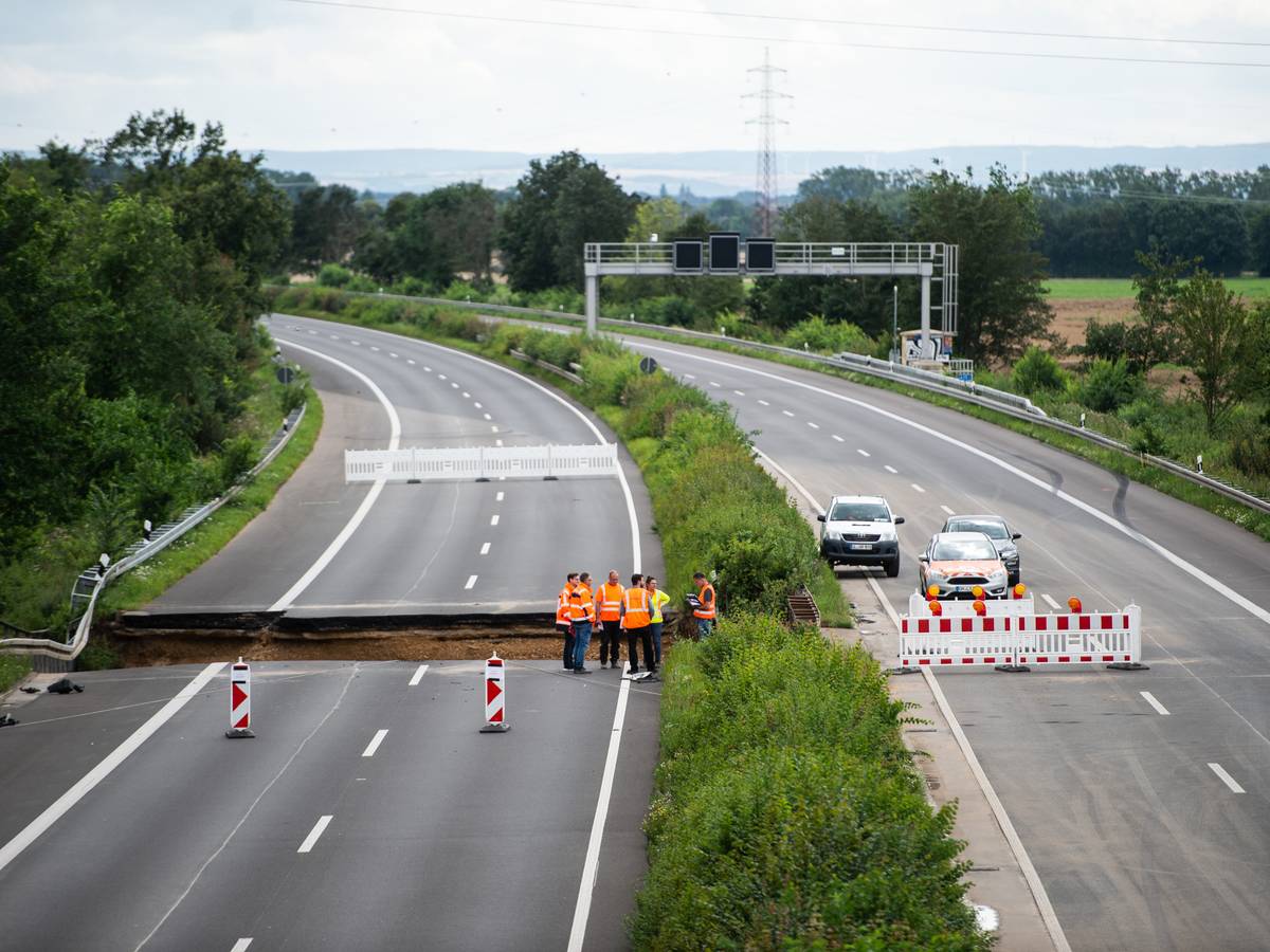 Arbeiter stehen auf der Autobahn A1 bei Erftstadt.