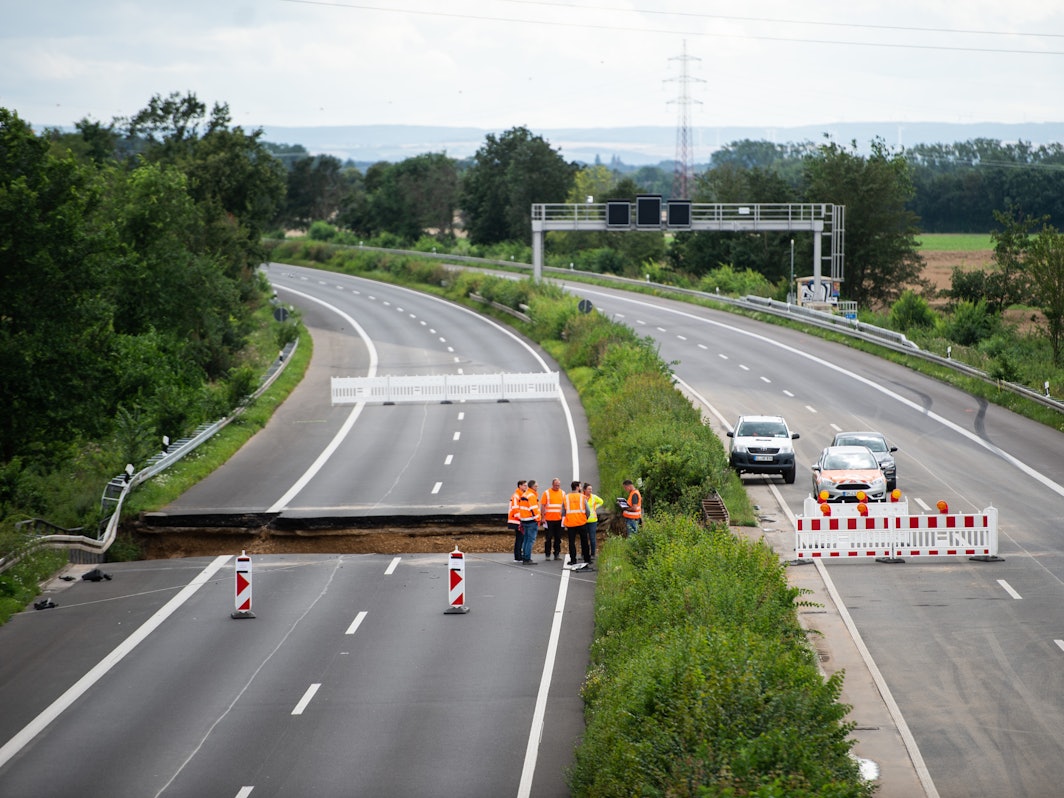 Arbeiter stehen auf der Autobahn A1 bei Erftstadt.