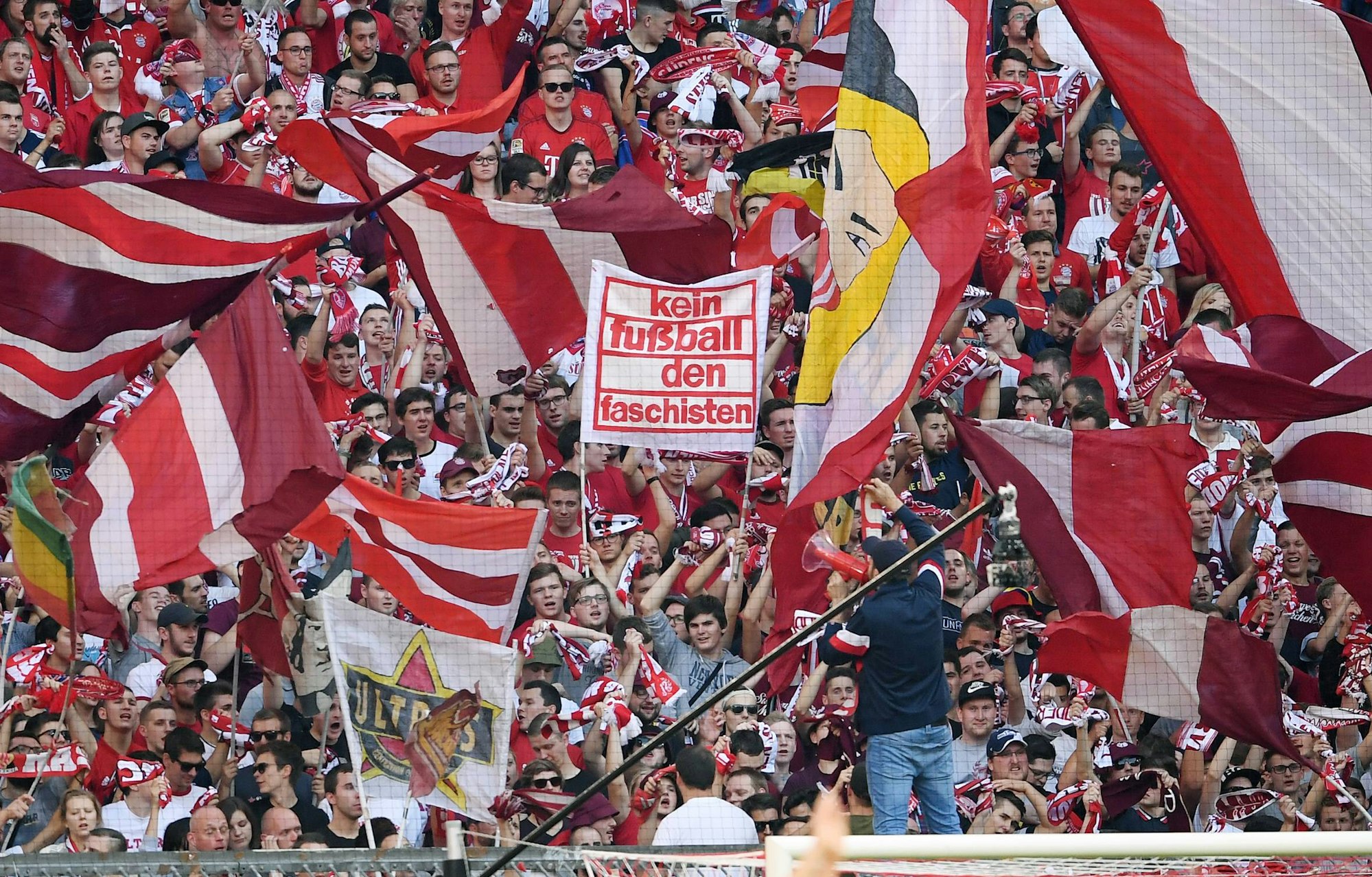 Bayernfans stehen in der Südkurve und schwenken Fahnen.