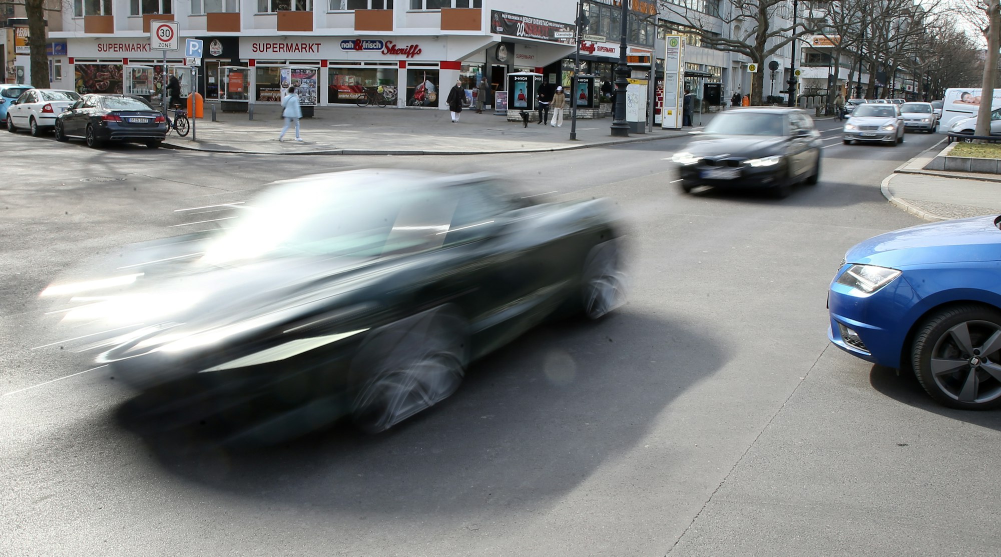 In rasantem Tempo fährt ein Auto über eine Straße.
