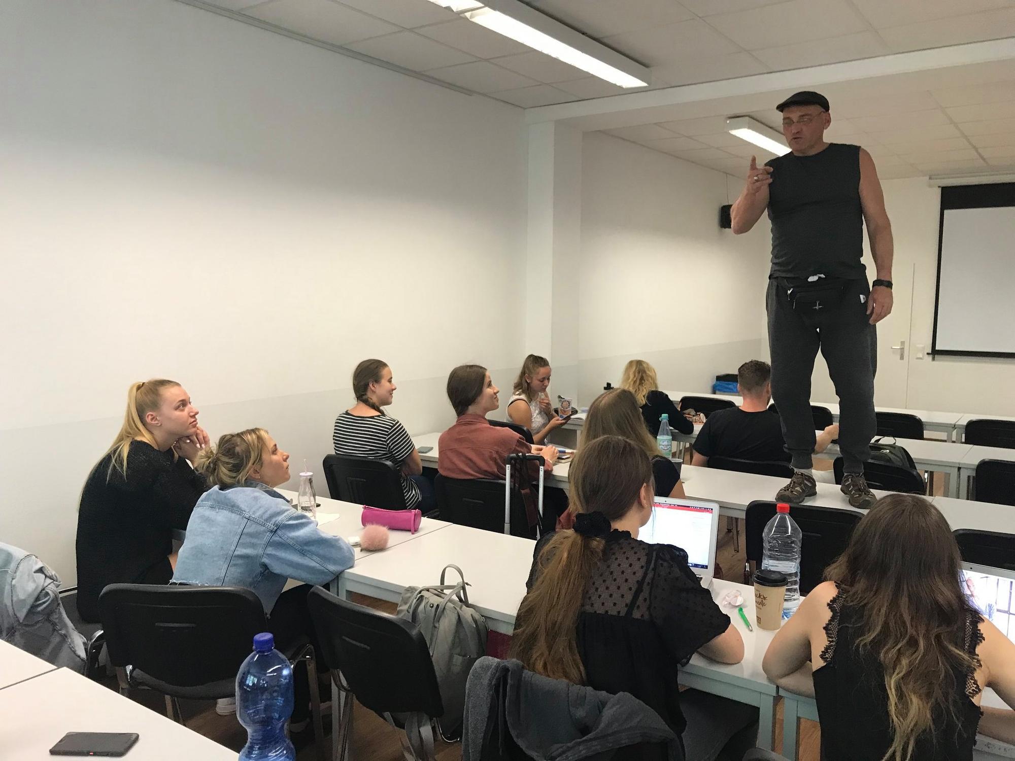 Streetworker Franco Clemens steht bei einem Seminar auf dem Tisch und spricht zu Jugendlichen.