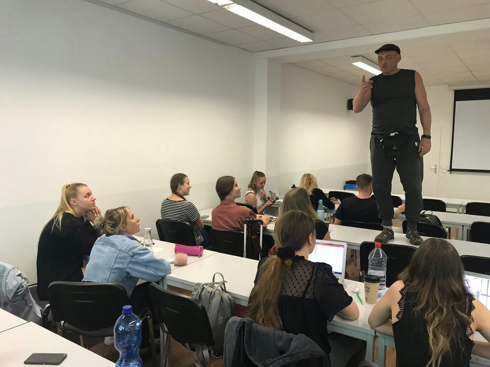 Streetworker Franco Clemens steht bei einem Seminar auf dem Tisch und spricht zu Jugendlichen.