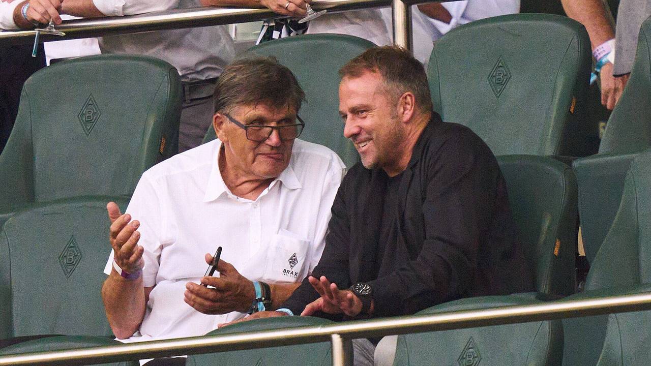 Hansi Flick sitzt in Mönchengladbach neben Hans Meyer auf der Tribüne.